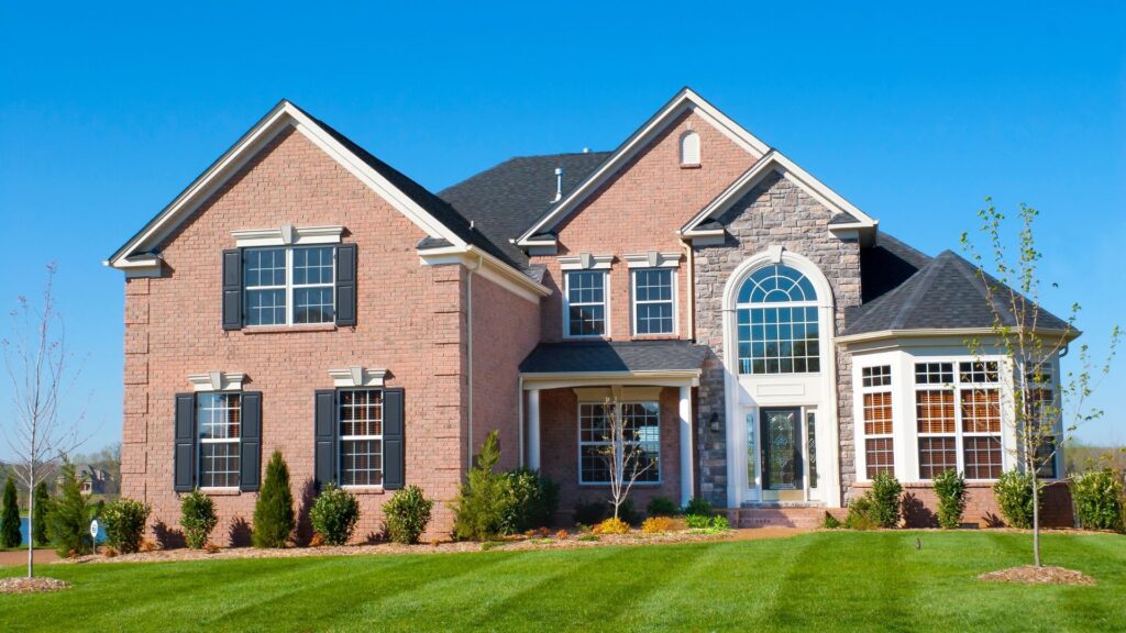 large brick home with bright green grass