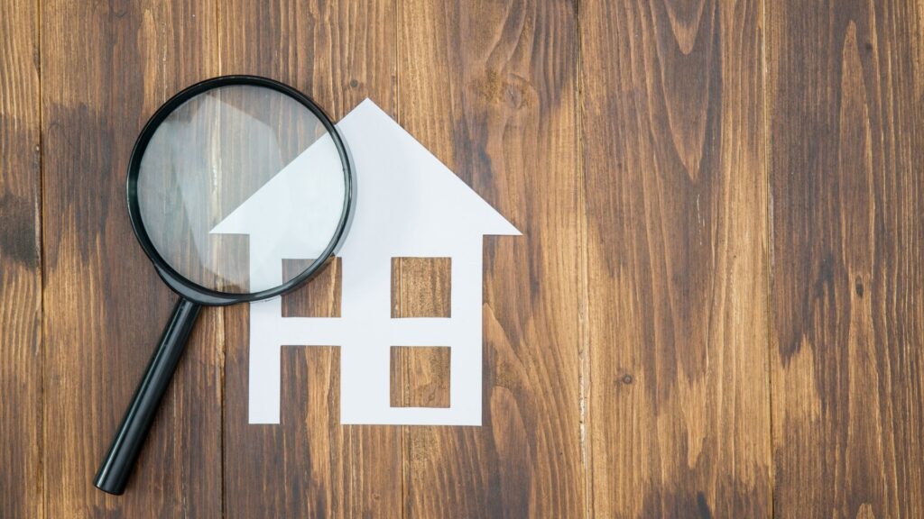 simple cut out of a house with a magnifying glass