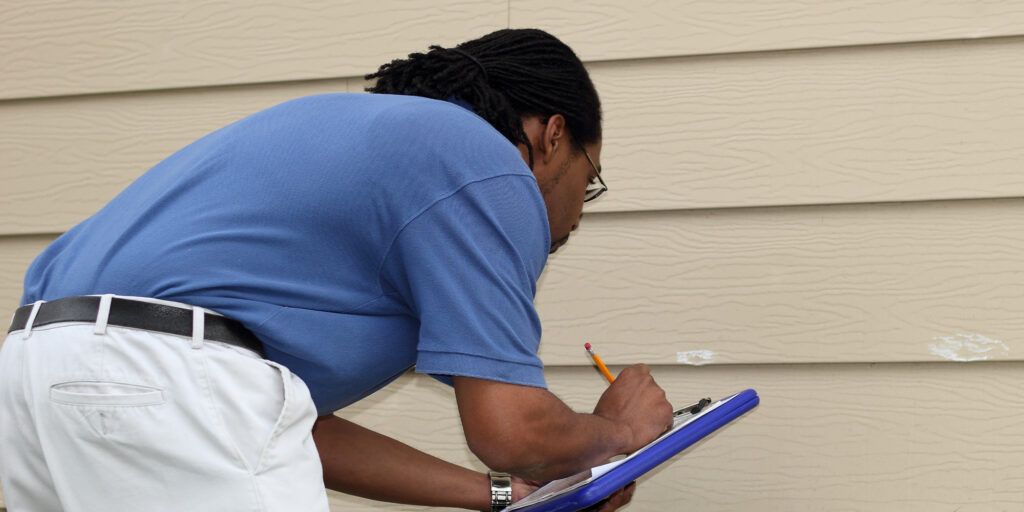 man reviewing the exterior of a home