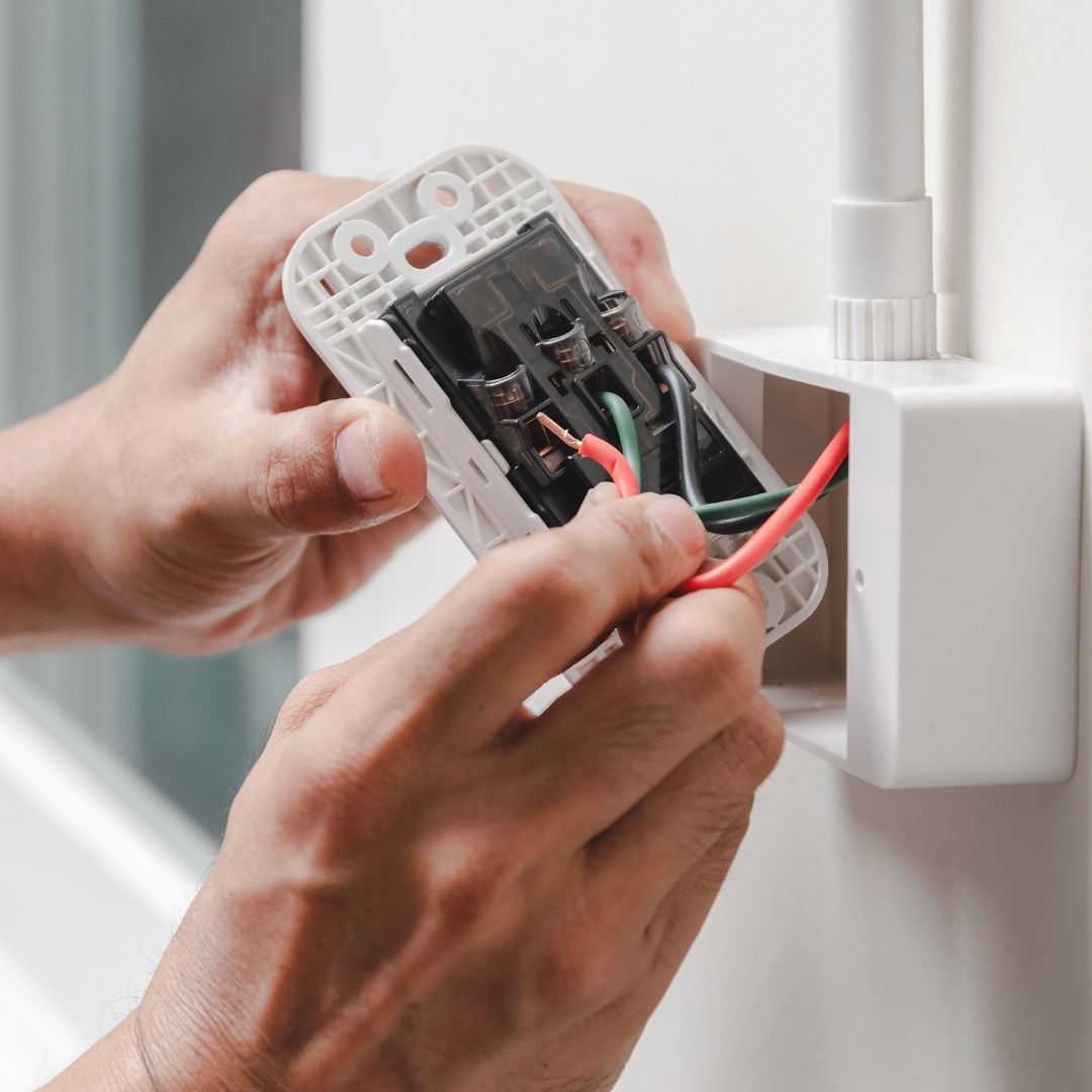 Person fixing electrical outlet